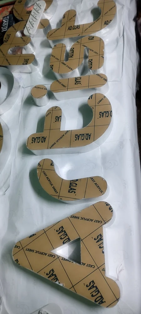 Cast acrylic lettering in production with protective film